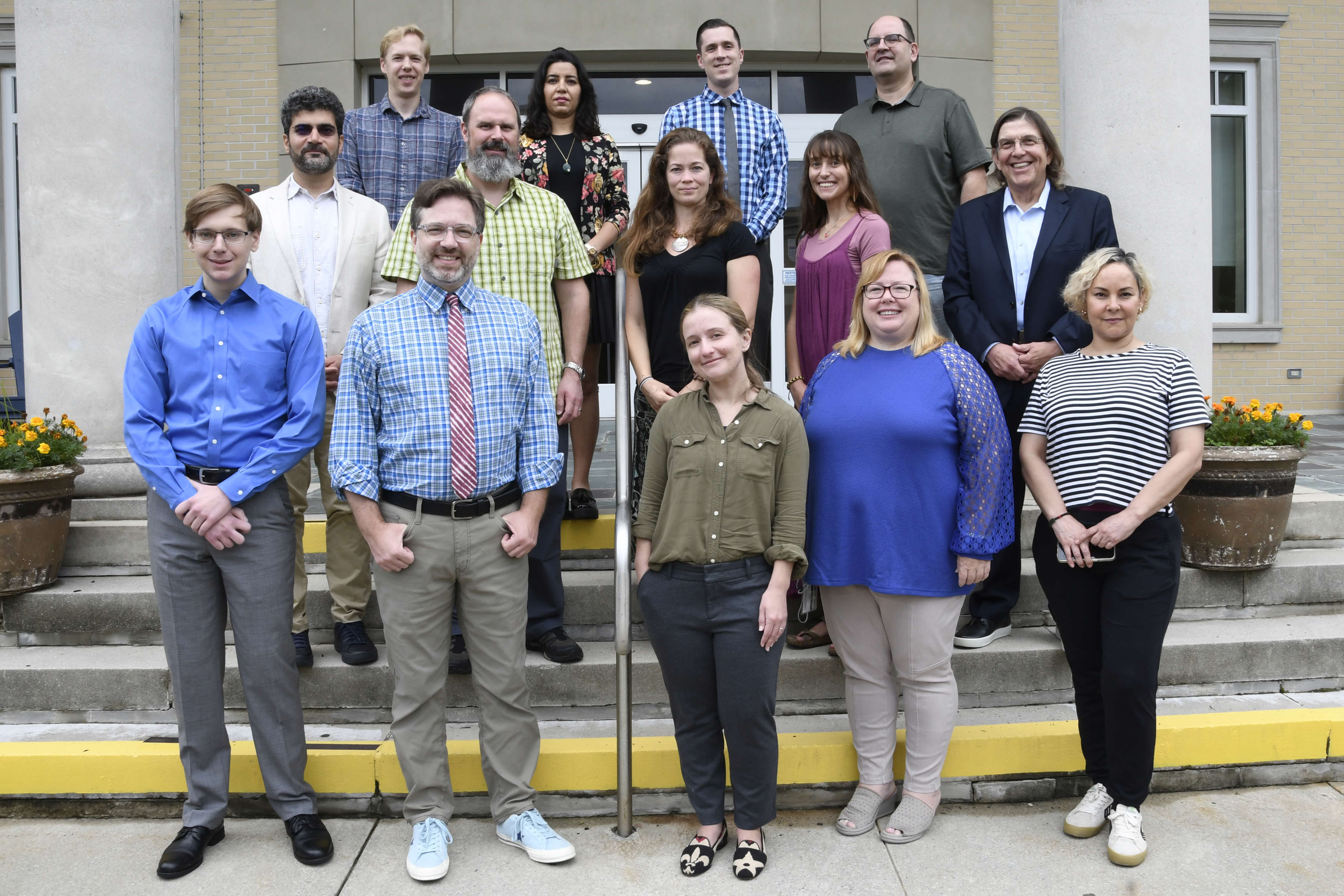 Photo of 14 new faculty members posing on front steps of Scarborough Library.