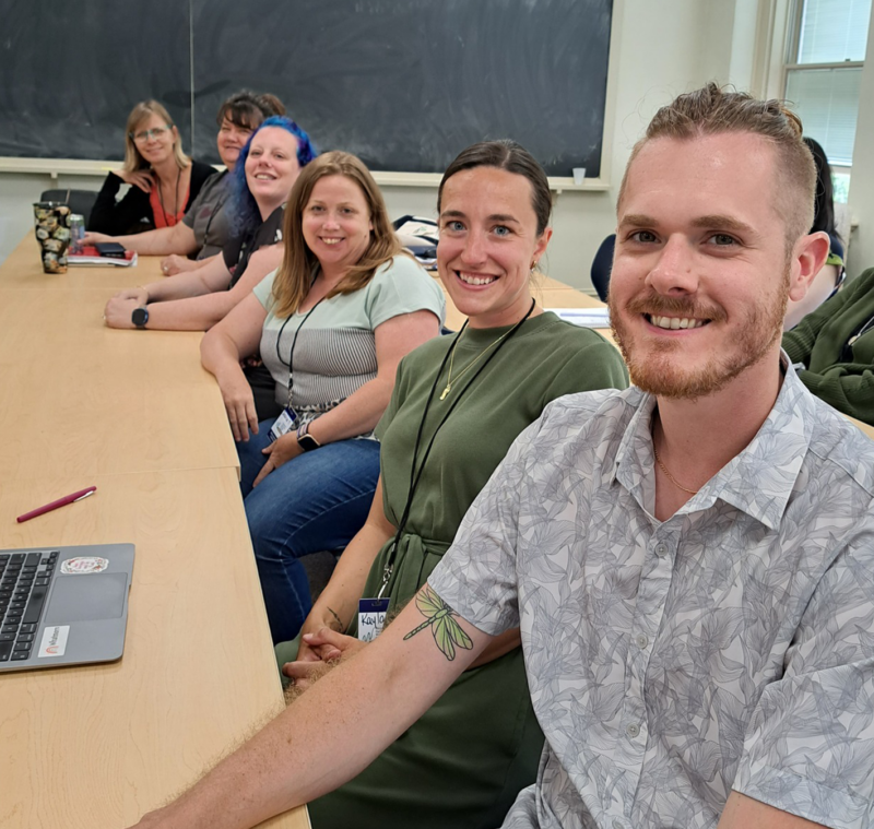 Graduate students sitting at a long table.